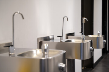 Close up of modern stainless steel drinking fountains in public building.