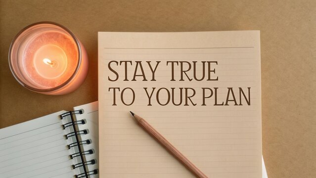 Inspirational message on notebook with candle and pencil, emphasizing commitment to personal goals and plans in cozy setting