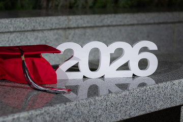 Graduation Cap and 2026 Sign on a Stone Surface in a Peaceful Garden Setting During the Evening