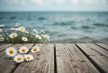 Bunch of white daisy flowers on rustic wooden pier, calm blue ocean water background, summer holiday travel nature scene.