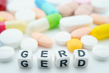 GERD Gastro esophageal Reflux Disease word with pills and capsules medical drug.