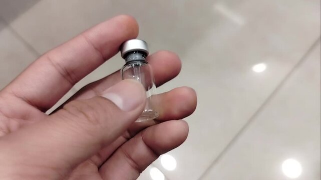 used ampoule bottle in man's hand