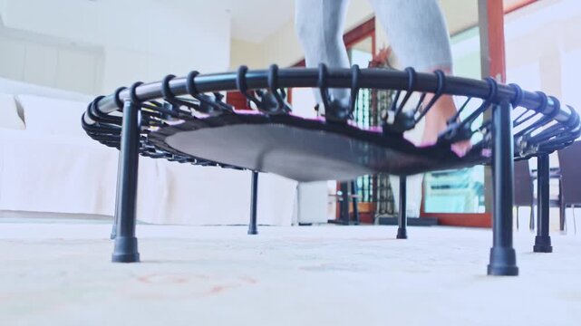 Woman's legs jumping on a mini trampoline during home workout