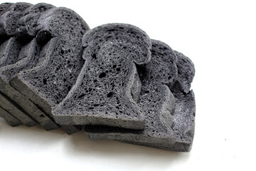 Black charcoal bread slices on white background