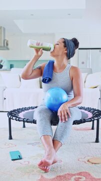 Healthy woman drinking a green smoothie after home workout