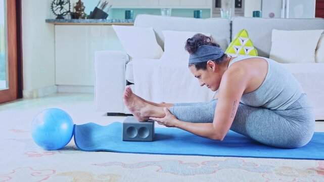 Flexible woman stretching hamstrings in a living room