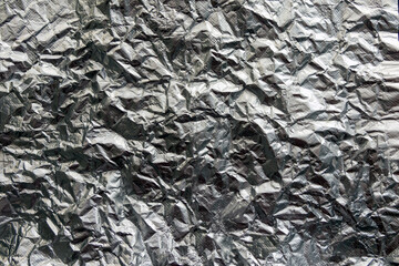 Crumpled foil paper. Silver background made of metallic textured paper.