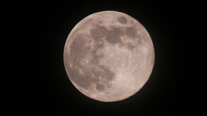A Detailed Close-Up View of the Luminous Full Moon, Clearly Showcasing its Textured Surface, Craters, and Dark Maria Against a Black Sky.
