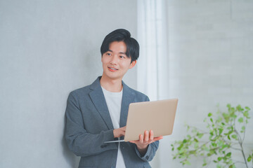 ノートパソコンを持っているオフィスカジュアルの男性