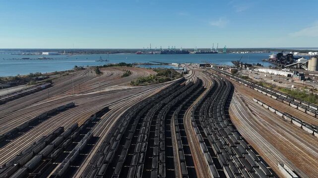 Norfolk Virginia port rail yard and cargo trains with Hampton Roads harbor 4k aerial drone video