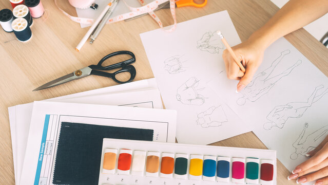 Hand sketching costume pattern on table creative at fashion designer studio workspace