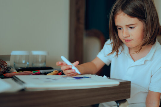 Puzzled Little Girl Trying to Draw Something from Imagination. Frustrated child finding it difficult to express on paper
