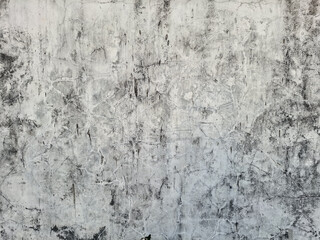 Fototapeta premium ​Old, distressed gray concrete wall background with cracks and grunge texture. Cement surface, weathered, aged, vintage, rough, dark, dirty, abstract backdrop.