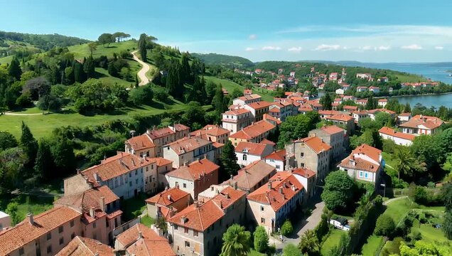 Scenic 4K aerial footage displaying red roofed houses surrounded lush greenery rolling hills clear blue sky offering timeless beauty toric charm