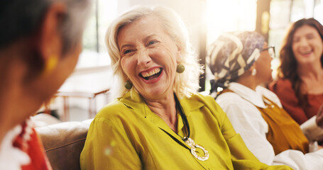 Fototapeta premium Laughing, old women and gossip on couch, home and bonding with friends in lounge, happy and reunion. Senior people, conversation and humor for funny joke in living room, flare and break in apartment