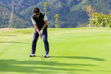 ゴルフを楽しむ日本人のミドル男性