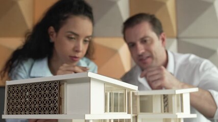 Professional architect engineer team discuss about house model construction. Skilled project manager brainstorming about house material and structure problems. Business design concept. Manipulator.