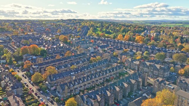 Aerial panoramic view over Harrogate, North Yorkshire, shows a grid of stone-built Victorian and Edwardian terraces surrounded by mature trees in peak autumn color.