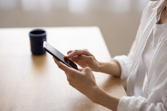 Smiling Woman Using Smartphone at Table