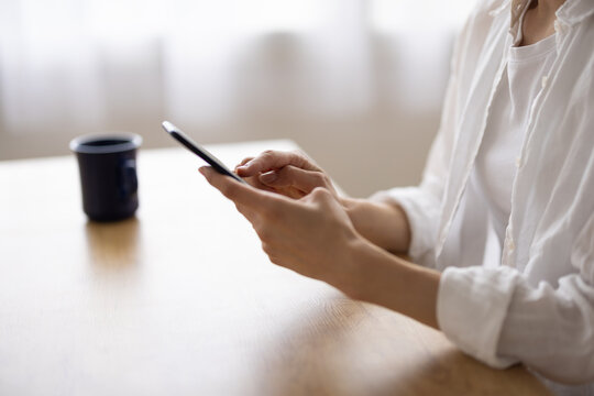 Smiling Woman Using Smartphone at Table