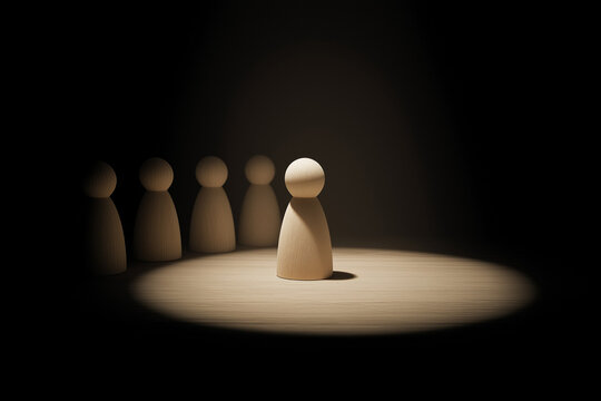 Lonely wooden doll separated from group of figures under spotlight, symbolizing social exclusion, anxiety, and mental health challenges in school or society 