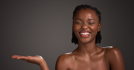 Mockup space, skincare and happy black woman in studio for product placement, beauty and wellness....