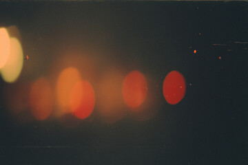 Blurry orange circular lights against a dark faded background. Perfect for background designs, abstract concepts, festive graphics, and artistic projects.