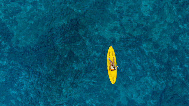 Aerial view of a kayak in the blue sea .man kayaking he does water sports activities.	