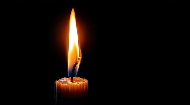 Single candle flame against a black background