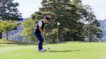 ゴルフを楽しむ日本人のミドル男性