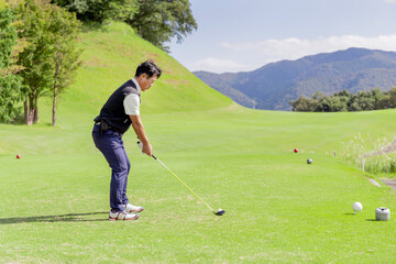 ゴルフを楽しむ日本人のミドル男性