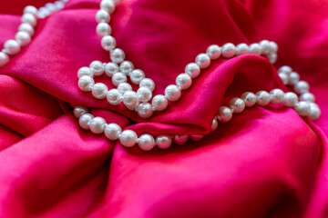 pearl beads lie on red silk
