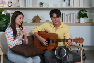 Musical Moment. A young couple enjoying a guitar session together in a cozy living room.