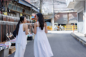 Naklejka premium Young asian women talking walking street market
