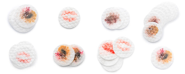 Set of cotton pads after makeup removal on white background, top view
