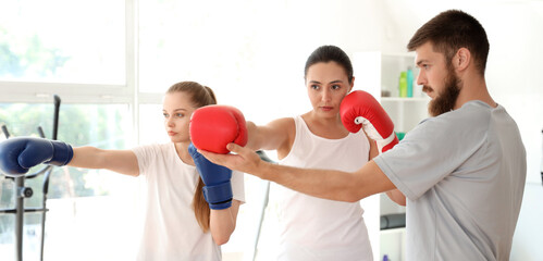 Instructor teaching young women to fight in gym. Concept of self defense