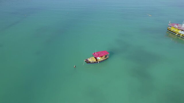 Drone footage of anse la mouche beach, bird eye view of tracking docking boats, calm ocean, Mahe, Seychelles 30fps