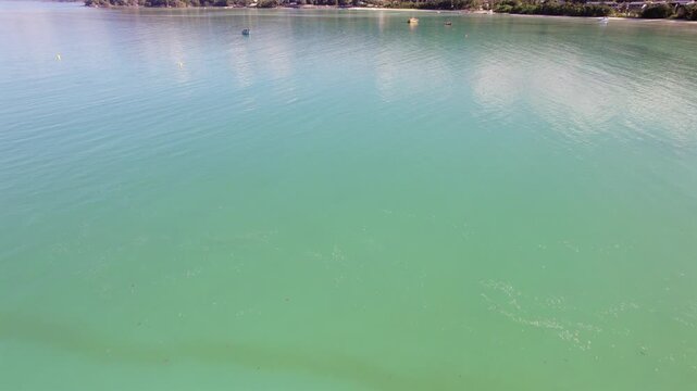 Drone footage of anse la mouche beach, docking boats, clam ocean, Mahe, Seychelles 30fps.
