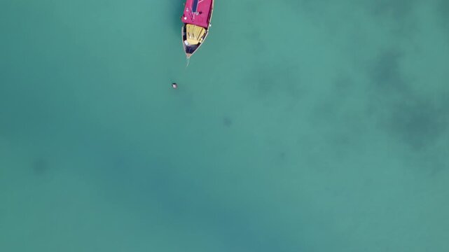 Drone footage of anse la mouche beach, bird eye view of docking boats, clam ocean, Mahe, Seychelles 30fps