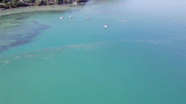 Drone footage of anse la mouche beach, passing fisherman boat and docking boats, calm ocean, Mahe, Seychelles 30fps