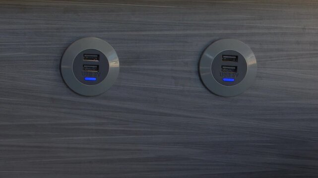 Close-up view of dual USB ports embedded in a sleek wooden panel, showcasing modern technology and design, camera slowly zooms in for detail
