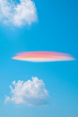 Fototapeta premium Iridescent cloud in a bright blue sky with puffy white clouds creating a beautiful scene
