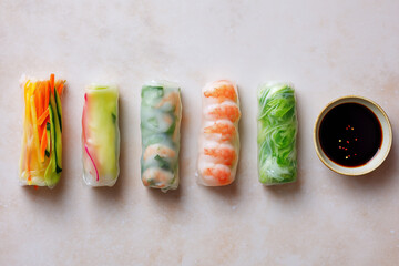 Fresh spring rolls filled with colorful vegetables and shrimp, served with dark dipping sauce, create vibrant and appetizing dish
