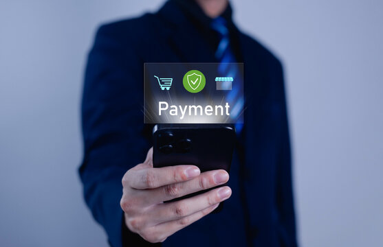 Businessman holding smartphone with digital payment interface, representing online shopping, secure transaction, and financial technology innovation for modern e-commerce business concept.