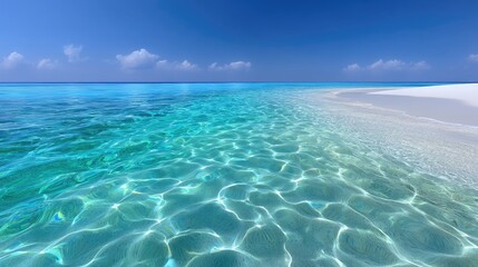 Crystal Clear Turquoise Ocean Water Shimmers Under Bright Blue Sky With Gentle Waves Touching a White Sand Beach Shoreline Peaceful Tropical Paradise