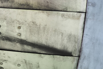 Macro view of aircraft fuselage surface showing riveted joints metal plates and structural lines on a multirole fighter jet