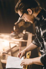 Professional carpenter sketch design furniture in wood workshop authentic handcraft working people.