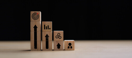 Business growth and success strategy concept with wooden blocks and icons representing teamwork, process, analytics, and goal achievement on black background.