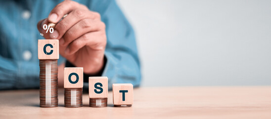 Cost management, finance, and business expense concept with wooden blocks forming the word COST on stacked coins, showing financial planning, interest rate, and growth idea.