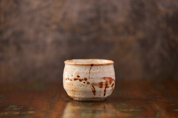 Traditional, handcrafted ceramic on wooden background.	Soft focus. Copy space. 